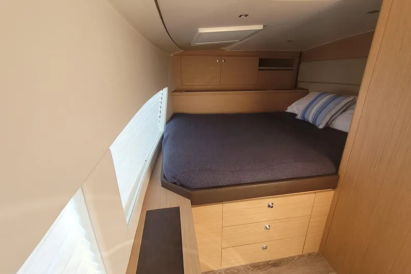  Yacht Photos Pics Luxurious cabin interior of 2025 Makai M37 with cozy bed and wooden storage.