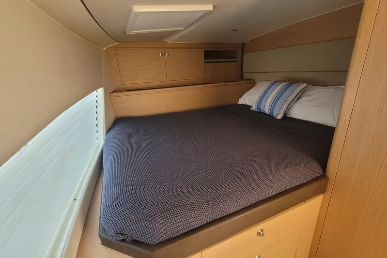  Yacht Photos Pics Cozy cabin interior of 2025 Makai M37 with comfortable bedding and wooden storage.