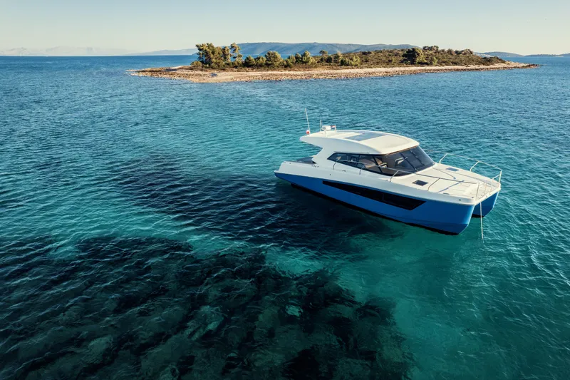  Yacht Photos Pics 2025 Makai M37 yacht cruising near a small island in clear blue waters.