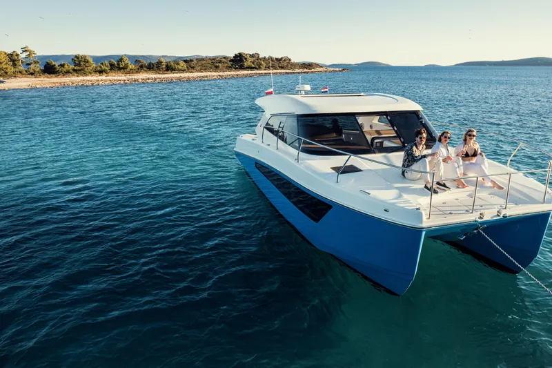  Yacht Photos Pics 2025 Makai M37 yacht with three people enjoying a sunny day on the water.