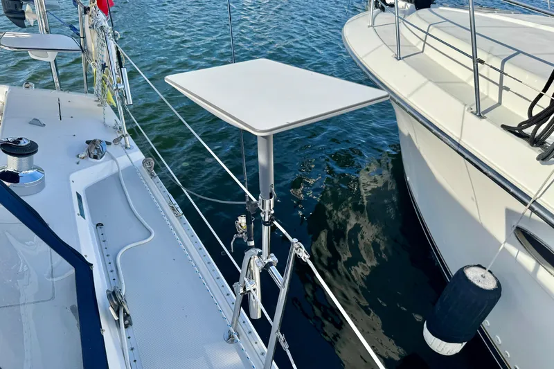 Ostrich Yacht Photos Pics 2004 Catalina 42 MkII sailboat deck with table, docked beside another boat.