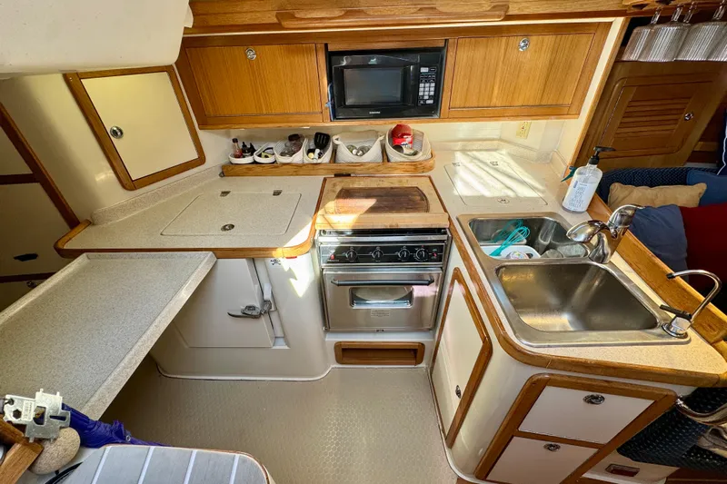 Ostrich Yacht Photos Pics 2004 Catalina 42 MkII yacht kitchen with stove, sink, and microwave in compact layout.