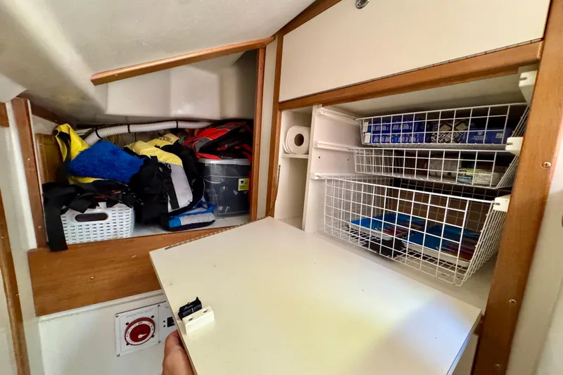 Ostrich Yacht Photos Pics Storage area inside a 2004 Catalina 42 MkII sailboat with organized shelves and supplies.