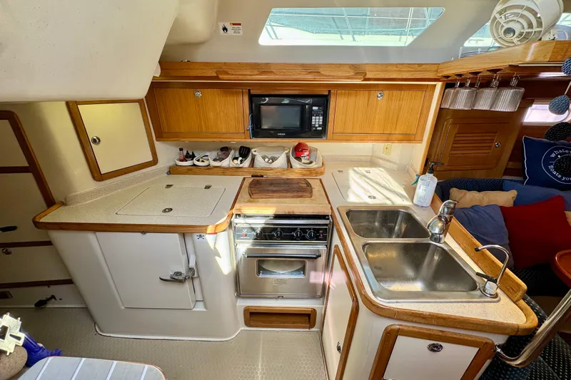 Ostrich Yacht Photos Pics 2004 Catalina 42 MkII yacht kitchen with wooden cabinets, dual sink, and stove.