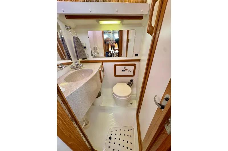 Ostrich Yacht Photos Pics Compact bathroom in a 2004 Catalina 42 MkII yacht, featuring sink, toilet, and mirror.