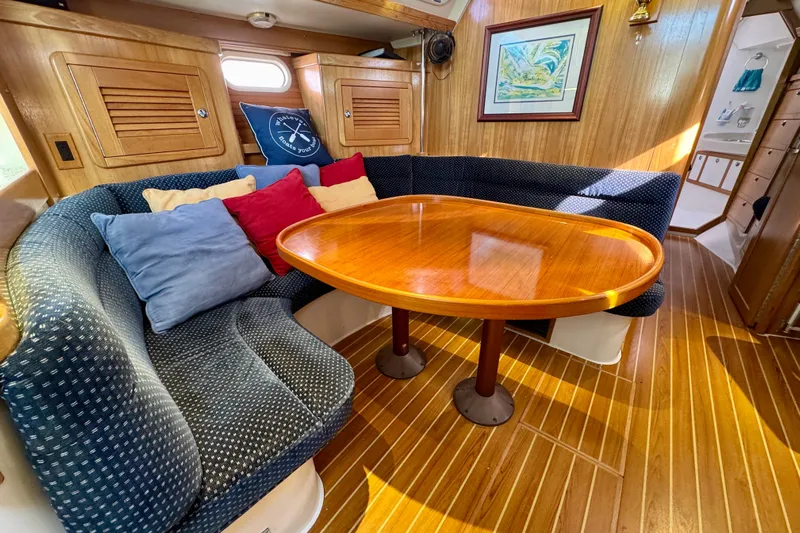 Ostrich Yacht Photos Pics Cozy interior of 2004 Catalina 42 MkII sailboat with wooden table and cushioned seating.