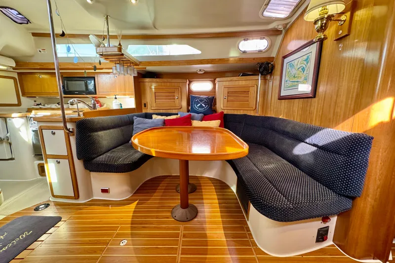 Ostrich Yacht Photos Pics Interior of 2004 Catalina 42 MkII sailboat with cozy seating and wooden table.