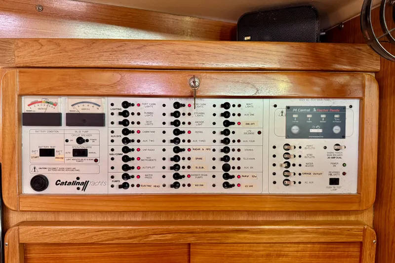 Ostrich Yacht Photos Pics Electrical control panel of a 2004 Catalina 42 MkII yacht, featuring various switches and gauges.