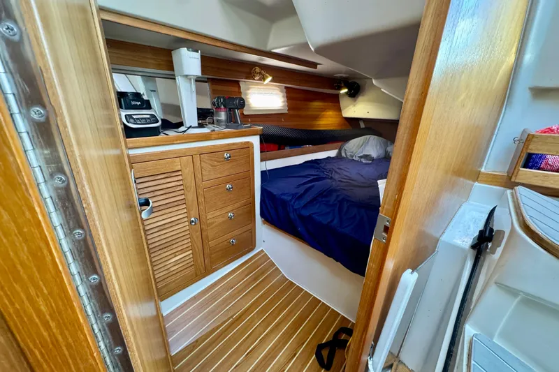 Ostrich Yacht Photos Pics Cozy cabin interior of 2004 Catalina 42 MkII sailboat with wooden cabinetry and bed.