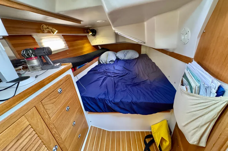 Ostrich Yacht Photos Pics Cozy cabin interior of 2004 Catalina 42 MkII sailboat with bed and wooden cabinetry.