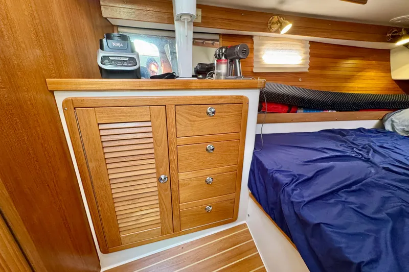 Ostrich Yacht Photos Pics Interior of 2004 Catalina 42 MkII sailboat with wooden cabinetry and blue bedding.