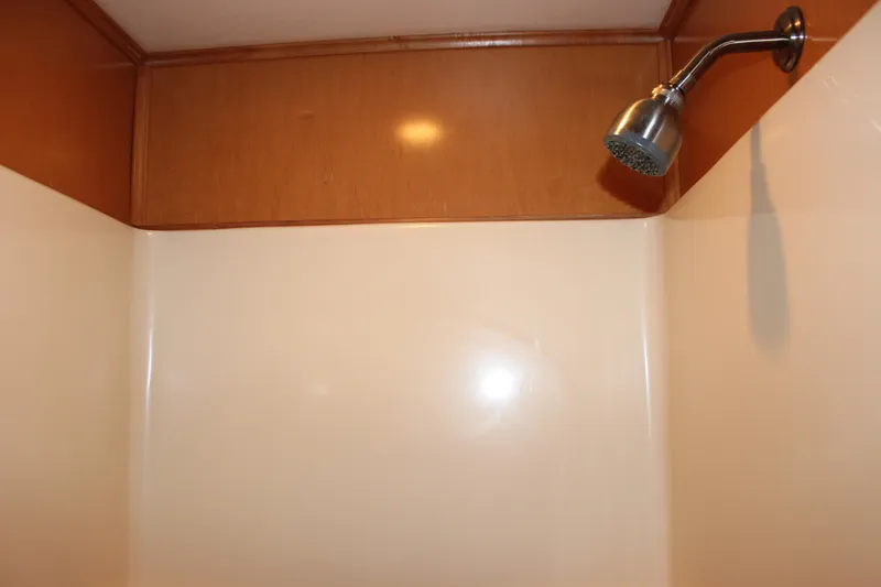  Yacht Photos Pics Shower area in 2007 Legacy Yachts Majestic, featuring wood paneling and chrome showerhead.