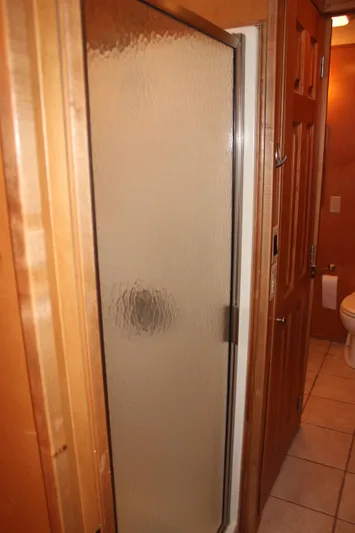  Yacht Photos Pics Shower area in 2007 Legacy Yachts Majestic, featuring frosted glass door and wooden trim.