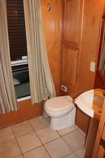  Yacht Photos Pics 2007 Legacy Yachts Majestic bathroom with wood paneling, toilet, and sink.