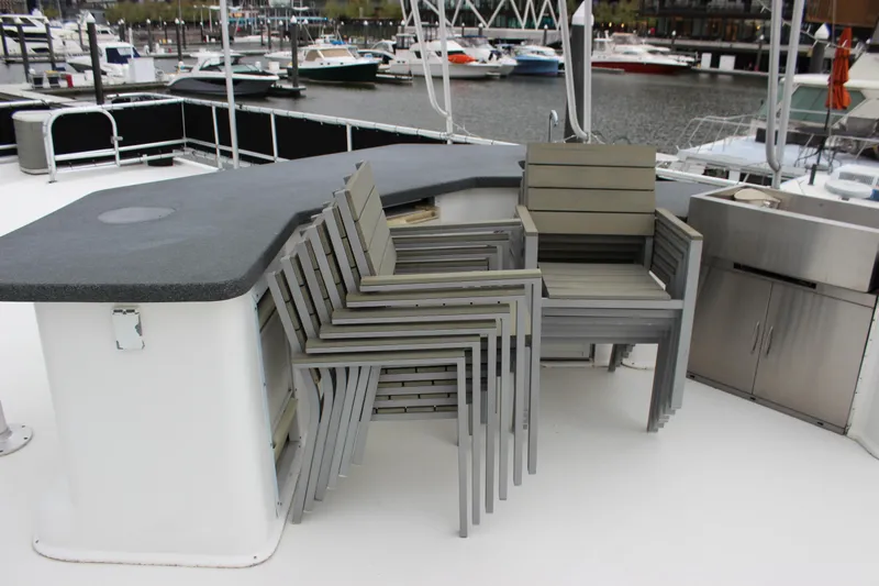  Yacht Photos Pics Stacked chairs on 2007 Legacy Yachts Majestic deck, with marina view in background.