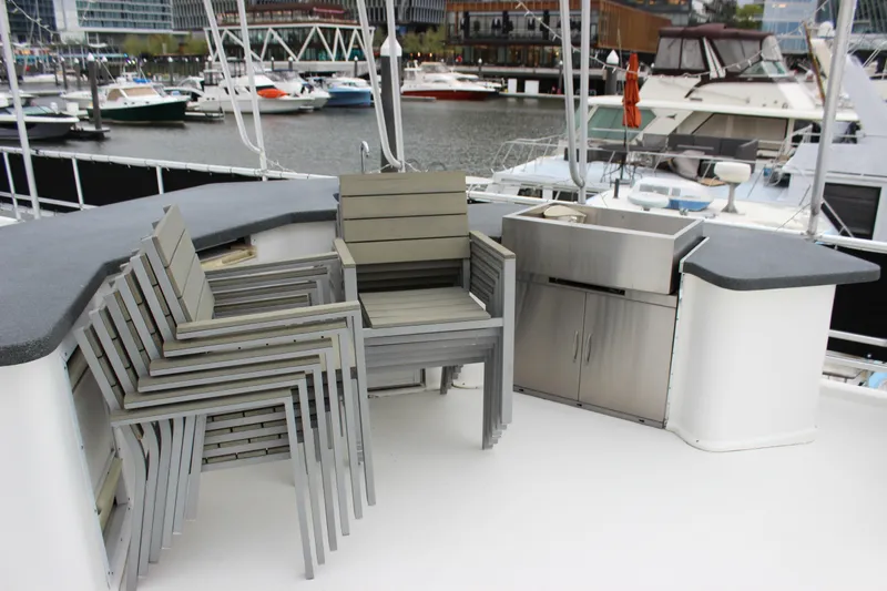  Yacht Photos Pics Deck of 2007 Legacy Yachts Majestic with stacked chairs and outdoor kitchenette.