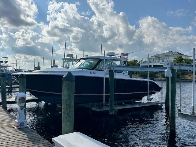  Yacht Photos Pics 2017 Pursuit DC 325 Dual Console boat docked at marina under cloudy sky.