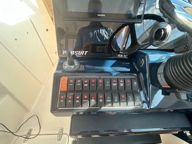  Yacht Photos Pics Control panel of a 2017 Pursuit DC 325 Dual Console boat with switches and Garmin display.