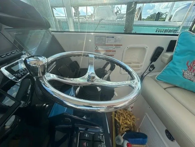  Yacht Photos Pics Steering wheel of a 2017 Pursuit DC 325 Dual Console boat, with control panel and seating.