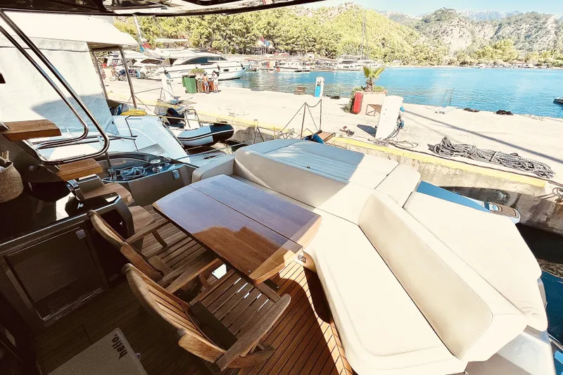  Yacht Photos Pics 2020 Cranchi E 52F Evoluzione yacht with elegant deck seating and scenic marina view.