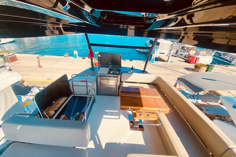  Yacht Photos Pics Flybridge of 2020 Cranchi E 52F Evoluzione yacht with seating and table, dockside view.