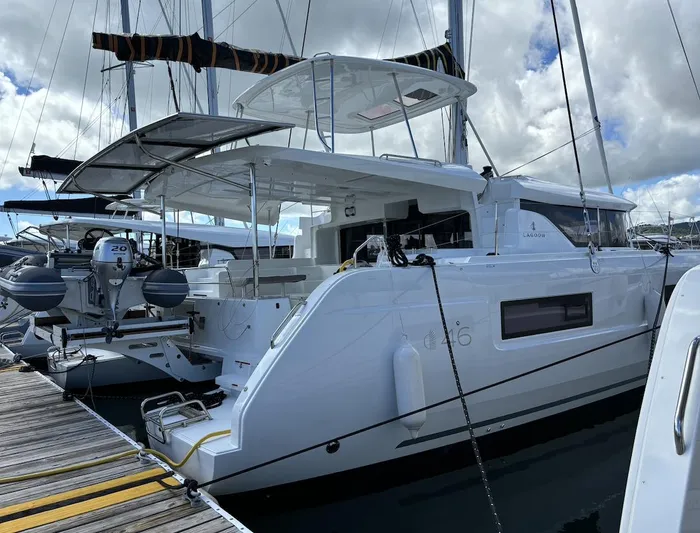  Yacht Photos Pics 2025 Lagoon 46 catamaran docked at marina under cloudy sky.