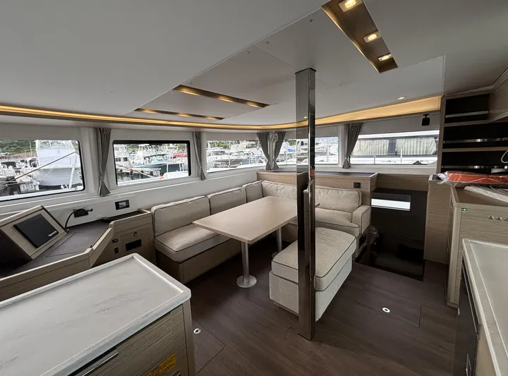  Yacht Photos Pics Luxurious interior of 2025 Lagoon 46 catamaran with modern seating and panoramic windows.