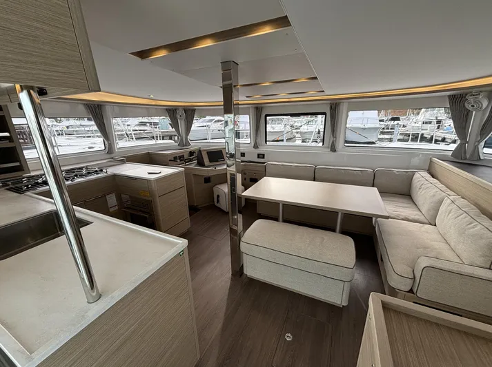  Yacht Photos Pics Luxurious interior of 2025 Lagoon 46 catamaran with modern kitchen and seating area.