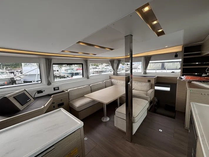  Yacht Photos Pics Interior of 2025 Lagoon 46 catamaran with modern seating and large windows.