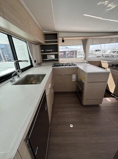  Yacht Photos Pics Modern kitchen interior of 2025 Lagoon 46 yacht with sleek countertops and appliances.