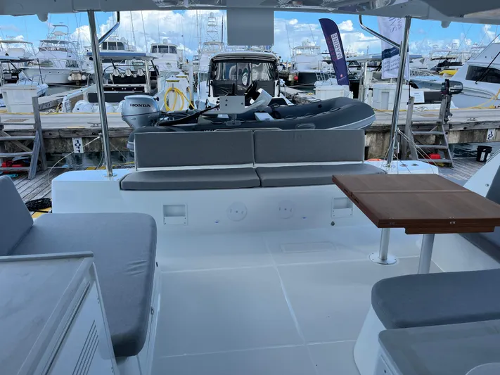 Yacht Photos Pics 2025 Lagoon 46 yacht interior with seating and table, docked at marina.