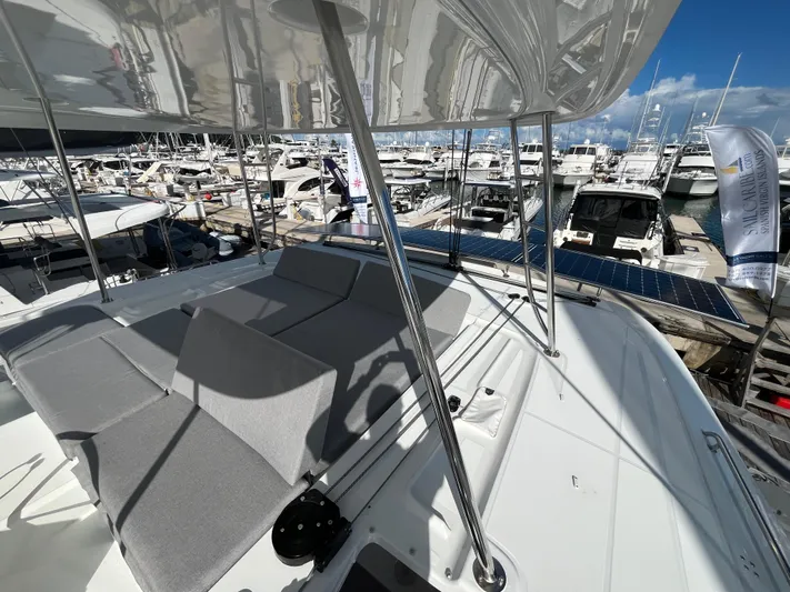  Yacht Photos Pics 2025 Lagoon 46 catamaran with spacious deck at marina, featuring modern design and comfortable seating.