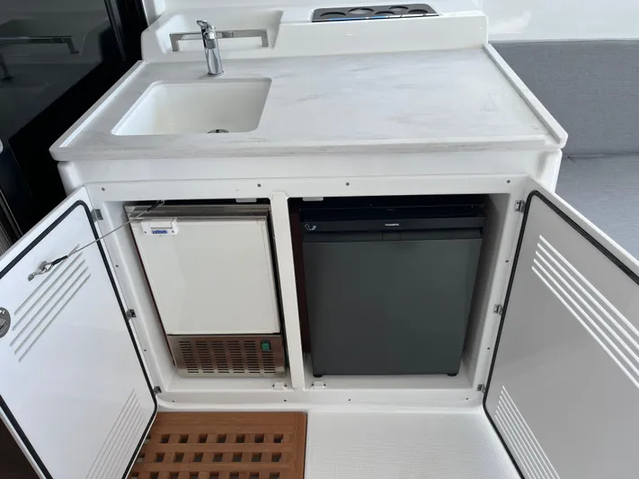  Yacht Photos Pics 2025 Lagoon 46 yacht kitchenette with sink, fridge, and storage cabinets.