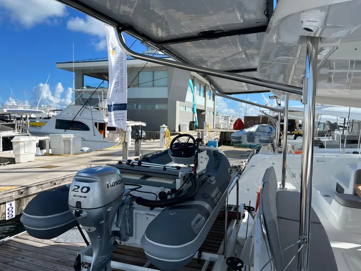  Yacht Photos Pics 2025 Lagoon 46 catamaran docked with inflatable boat and Honda outboard motor.
