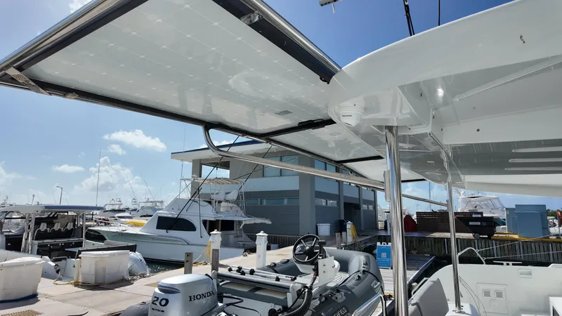  Yacht Photos Pics 2025 Lagoon 46 catamaran docked, featuring solar panels and a Honda outboard motor.