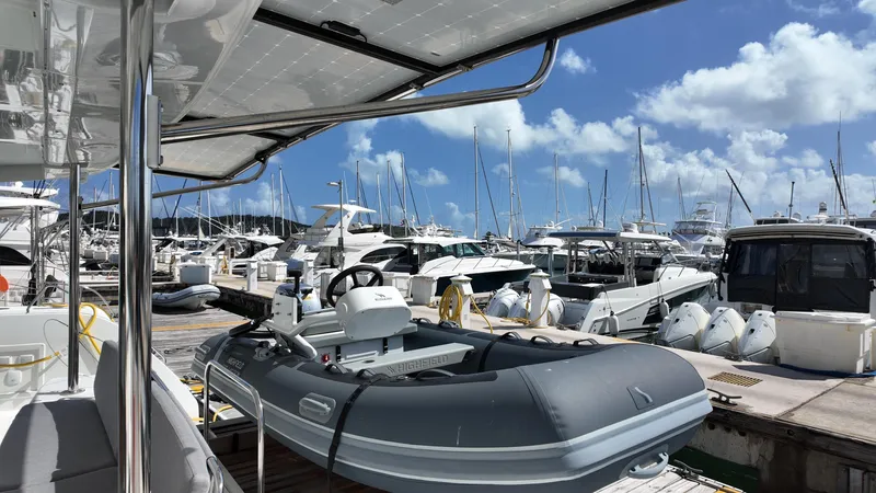 Yacht Photos Pics 2025 Lagoon 46 yacht at marina, surrounded by boats under a clear blue sky.