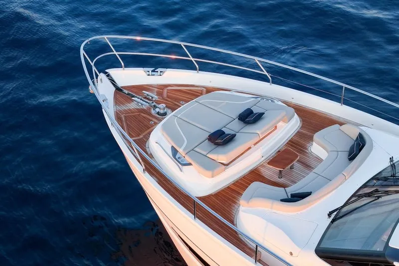  Yacht Photos Pics Luxurious 2025 Princess Y72 yacht deck with elegant seating and cushions on calm blue water.