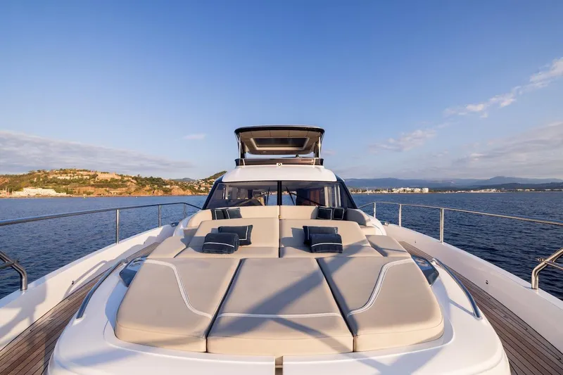  Yacht Photos Pics Luxurious 2025 Princess Y72 yacht with sunbathing deck, cruising on serene waters.