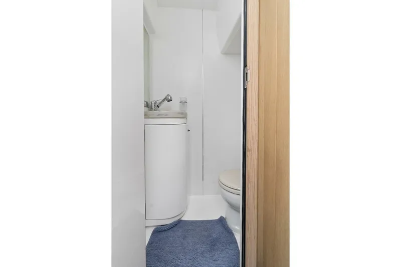 Above Deck Yacht Photos Pics Compact bathroom in 2018 Princess S60 yacht with sink, toilet, and blue rug.