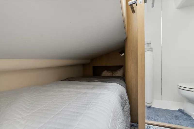 Above Deck Yacht Photos Pics Compact cabin bed with white bedding in 2018 Princess S60 yacht interior.