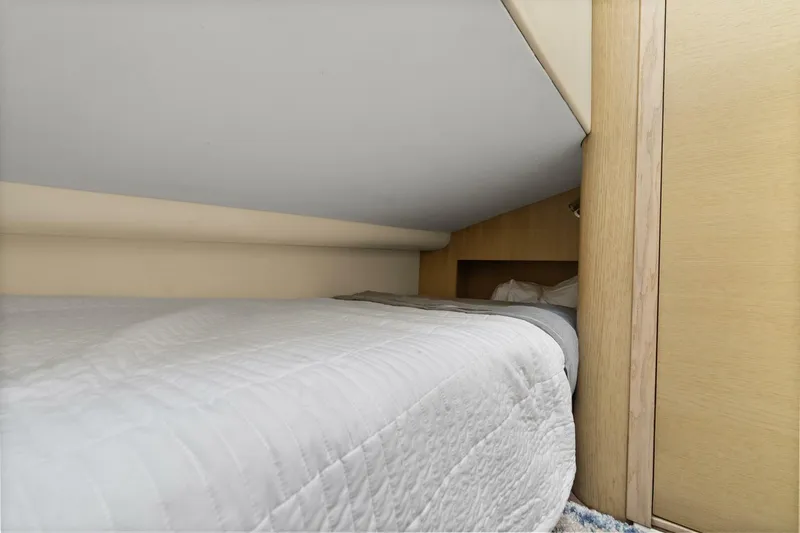 Above Deck Yacht Photos Pics Cozy cabin bed in 2018 Princess S60 yacht with white bedding and wooden accents.