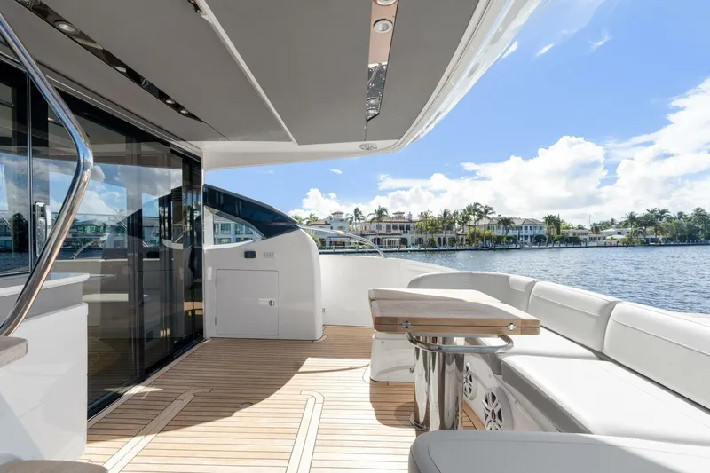 Above Deck Yacht Photos Pics Luxurious 2018 Princess S60 yacht deck with seating and table, overlooking waterfront homes.