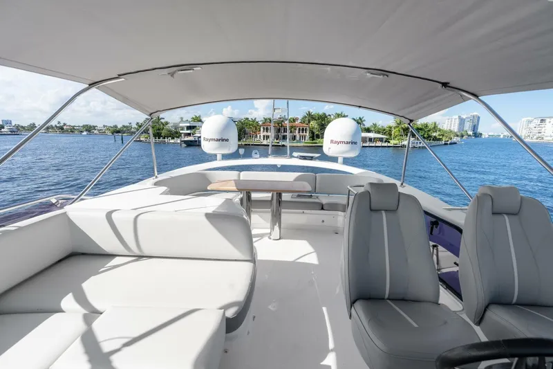 Above Deck Yacht Photos Pics Luxurious 2018 Princess S60 yacht interior with seating and Raymarine equipment, overlooking serene waters.