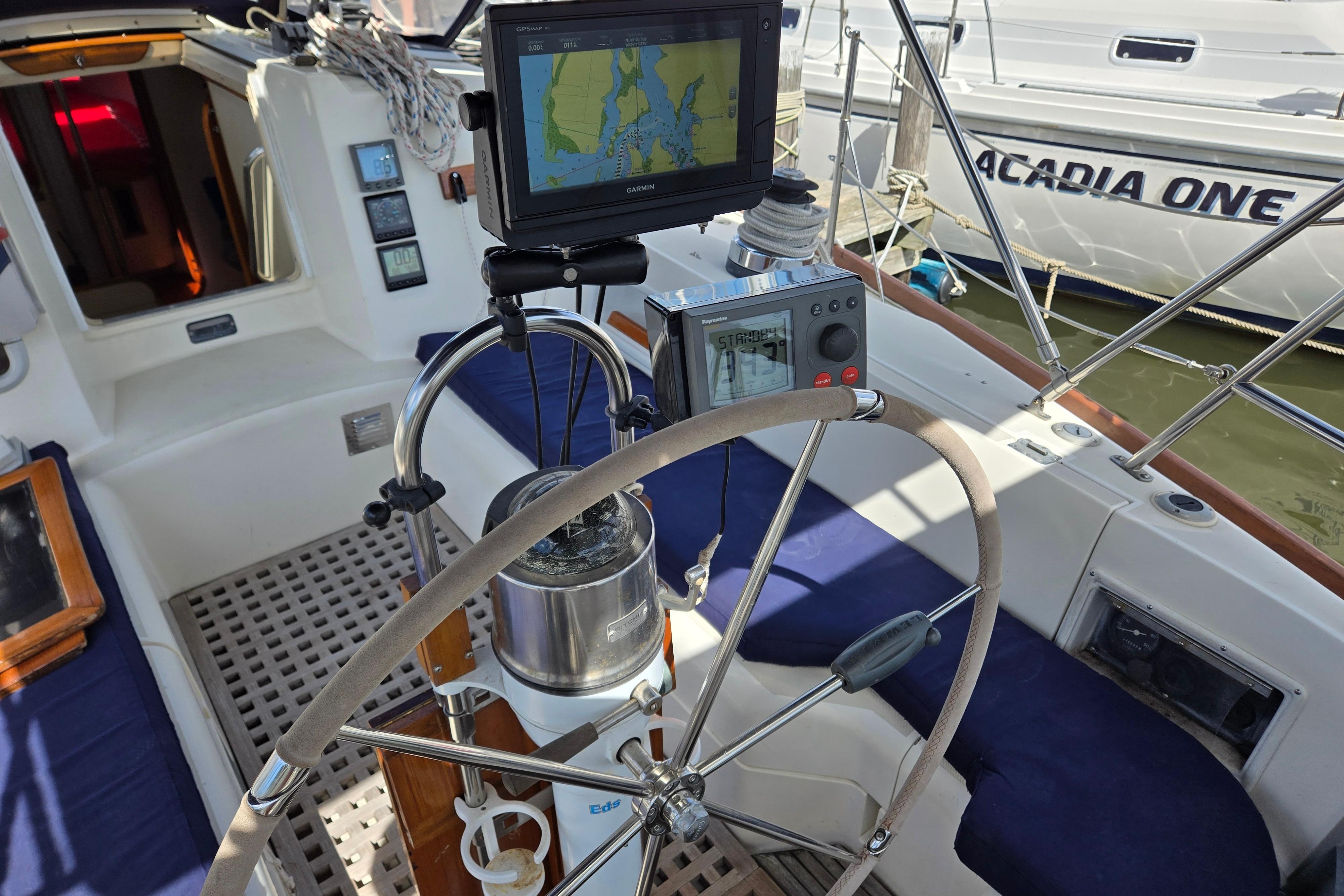 Cockpit of 1989 Pearson 37-2 sailboat with navigation equipment and steering wheel.