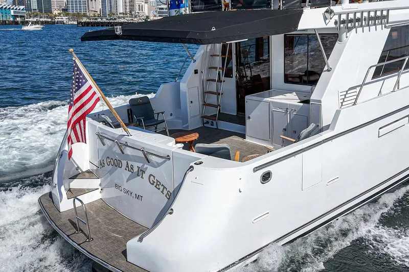 As Good As It Gets Yacht Photos Pics 2002 Ocean Alexander 640 Pilothouse yacht cruising with American flag, city skyline in background.