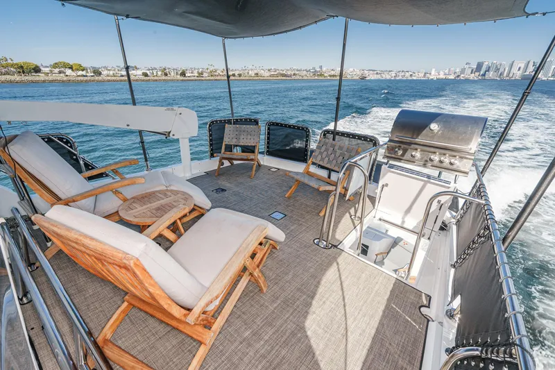 As Good As It Gets Yacht Photos Pics Luxurious 2002 Ocean Alexander 640 Pilothouse yacht deck with seating and grill, cruising near cityscape.