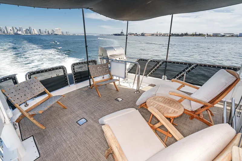 As Good As It Gets Yacht Photos Pics Luxurious 2002 Ocean Alexander 640 Pilothouse yacht deck with seating, ocean view, and city skyline.