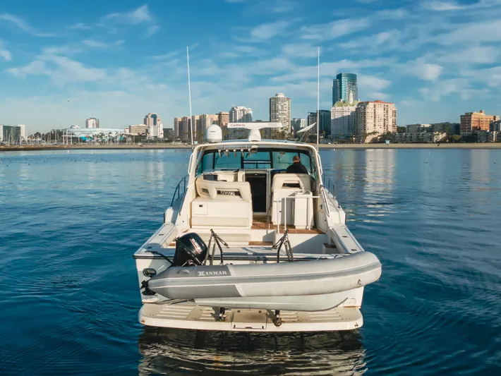Miss Michelle Yacht Photos Pics 1996 Tiara Yachts 4300 on calm water with city skyline in background.