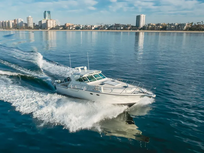 Miss Michelle Yacht Photos Pics 1996 Tiara Yachts 4300 cruising on calm waters near a city skyline.
