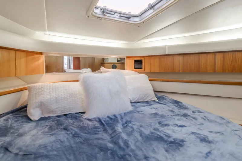 Miss Michelle Yacht Photos Pics Luxurious cabin interior of a 1996 Tiara Yachts 4300, featuring cozy bedding and wood accents.